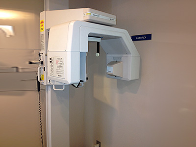 The image shows a dental chair with a built-in digital X-ray machine, which is currently not being used.