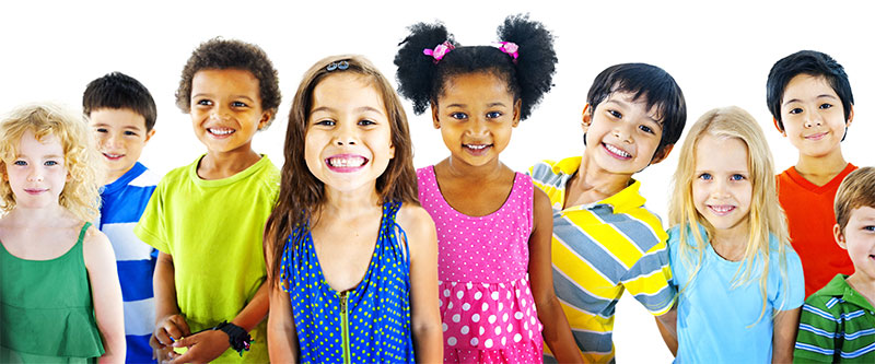 The image shows a group of children of various ages and ethnicities smiling at the camera against a plain background.